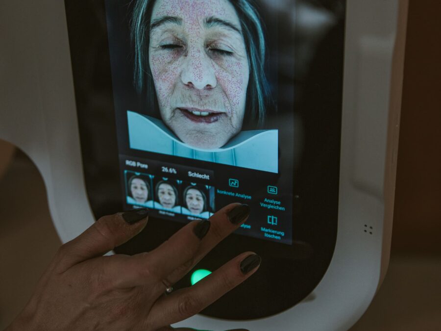 Auf einem Computerbildschirm in einem Kosmetikinstitut ist das Gesicht einer Frau zu sehen.