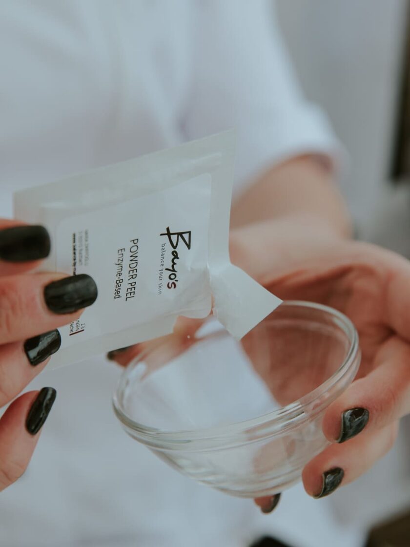 Eine Frau in Marias Kosmetikinstitut hält zum Ausgleich eine Packung Gesichtsmaske in einem Glas.