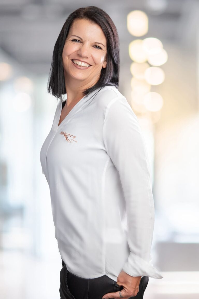 Eine lächelnde Frau in weißem Hemd und schwarzer Hose in Butzbach.
