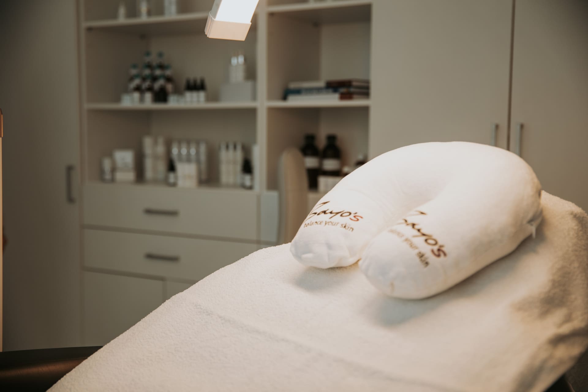 Ein weißes Kissen auf einem Bett in einem Schönheitssalon, der ästhetische Behandlungen anbietet.